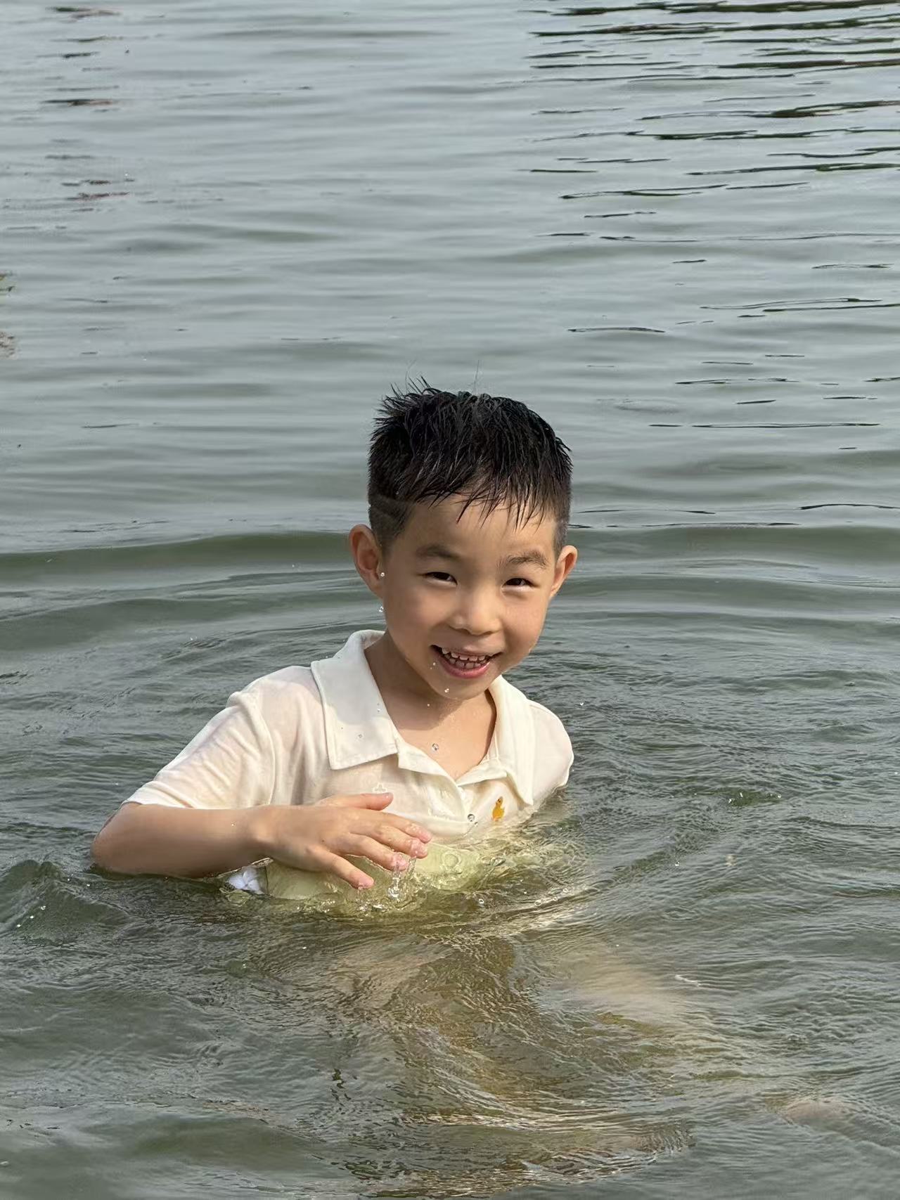 小鸣在水中开心玩耍的户外照片